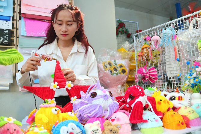 +ảnh 1: Chị Trang đang tạo các chi tiết để hoàn thành sản phẩm đèn ông sao bằng kẽm nhung.