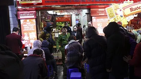 Người dân đội mưa xếp hàng dài mua vàng cầu may trong Ngày Thần Tài