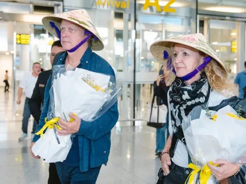 Thành viên Secret Garden thích thú khi được tặng nón lá vẽ tay thủ công ở sân bay Việt Nam